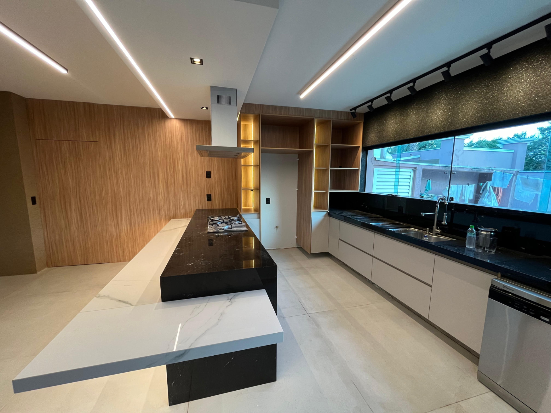 Cozinha planejada com ilha em mármore e iluminação linear