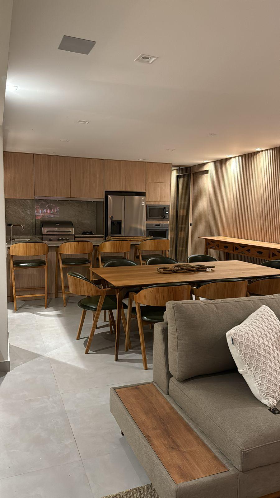 Área gourmet planejada com churrasqueira e mesa de jantar