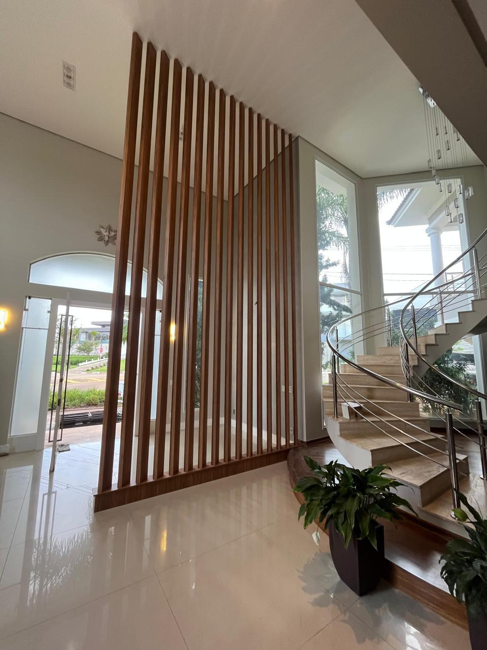 Painel ripado divisor de ambientes em hall com escada